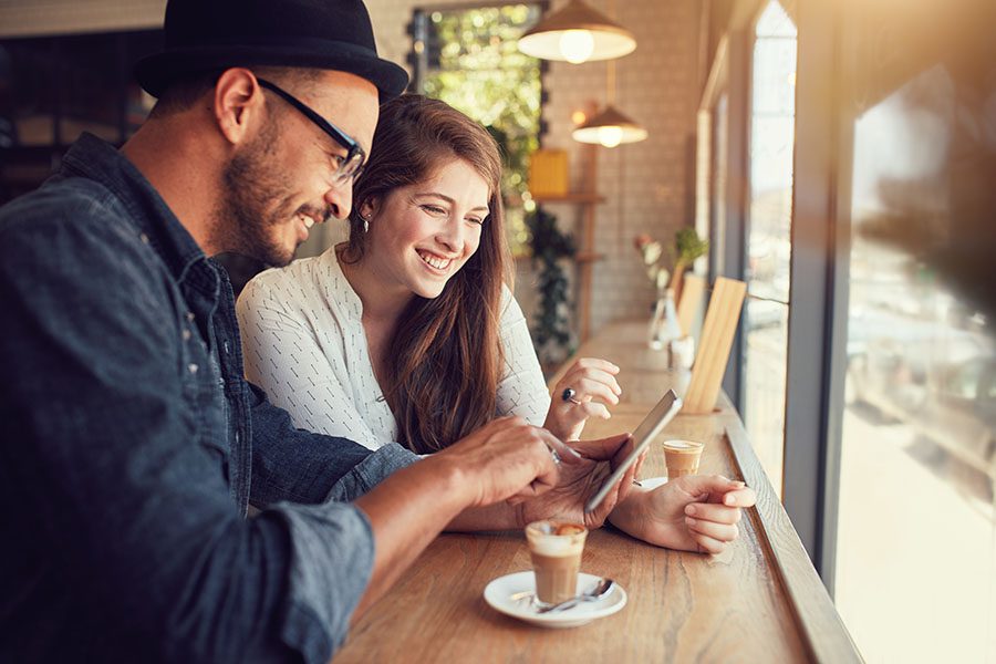Client Center - Smiling Young Couple Using Tablet In A Modern Cafe