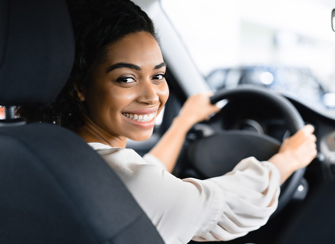 Driver Change Request - Woman Driver Turning Away from Road to Look Directly into the Camera